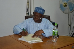 Alhaji Bako Abdullahi signing handover documents during the ceremony